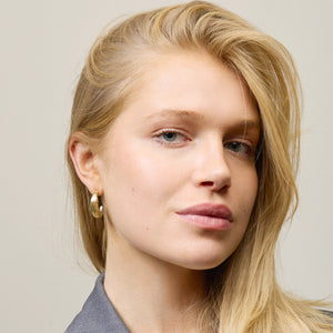 Model wearing gold earrings