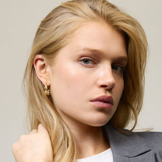 Model wearing gold earrings